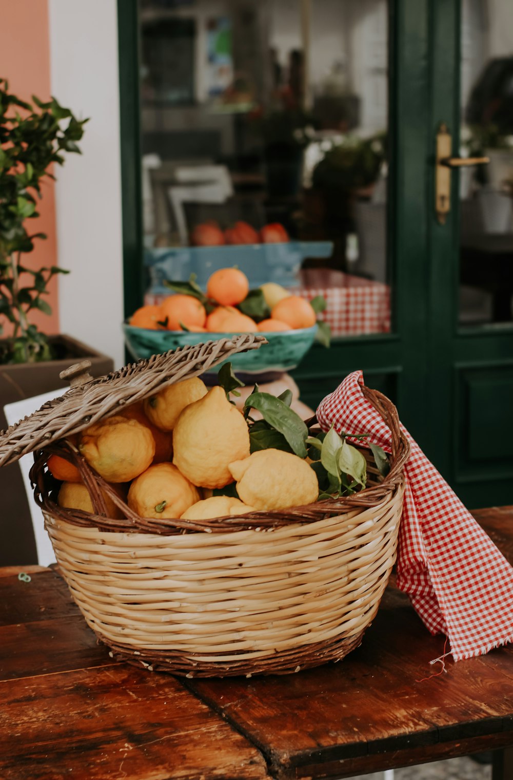 a basket of oranges sitting on a wooden table