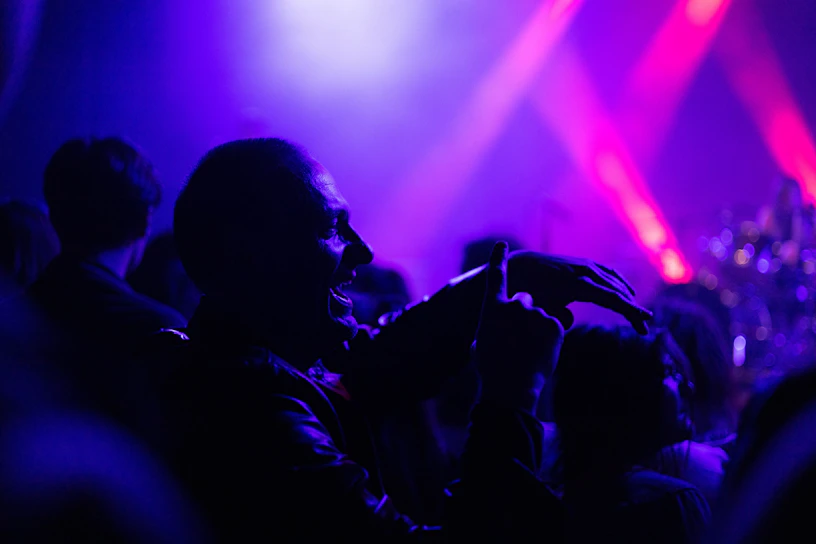 Vibrant live concert moment with the artist passionately singing under soft purple lights