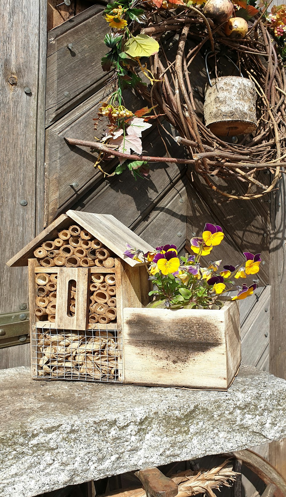 a birdhouse with flowers in it sitting on a ledge