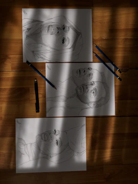 Close-up of pencil sketches on textured paper with charcoal accents.