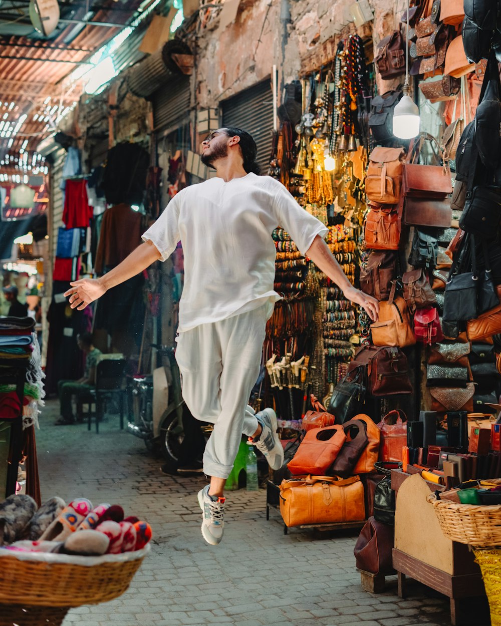 a man in white running through a market