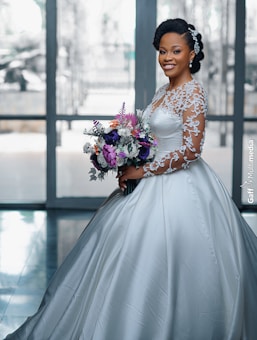 a woman in a wedding dress holding a bouquet of flowers