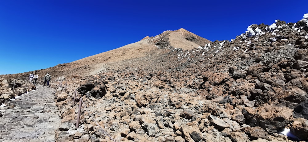 a group of people hiking up a rocky mountain