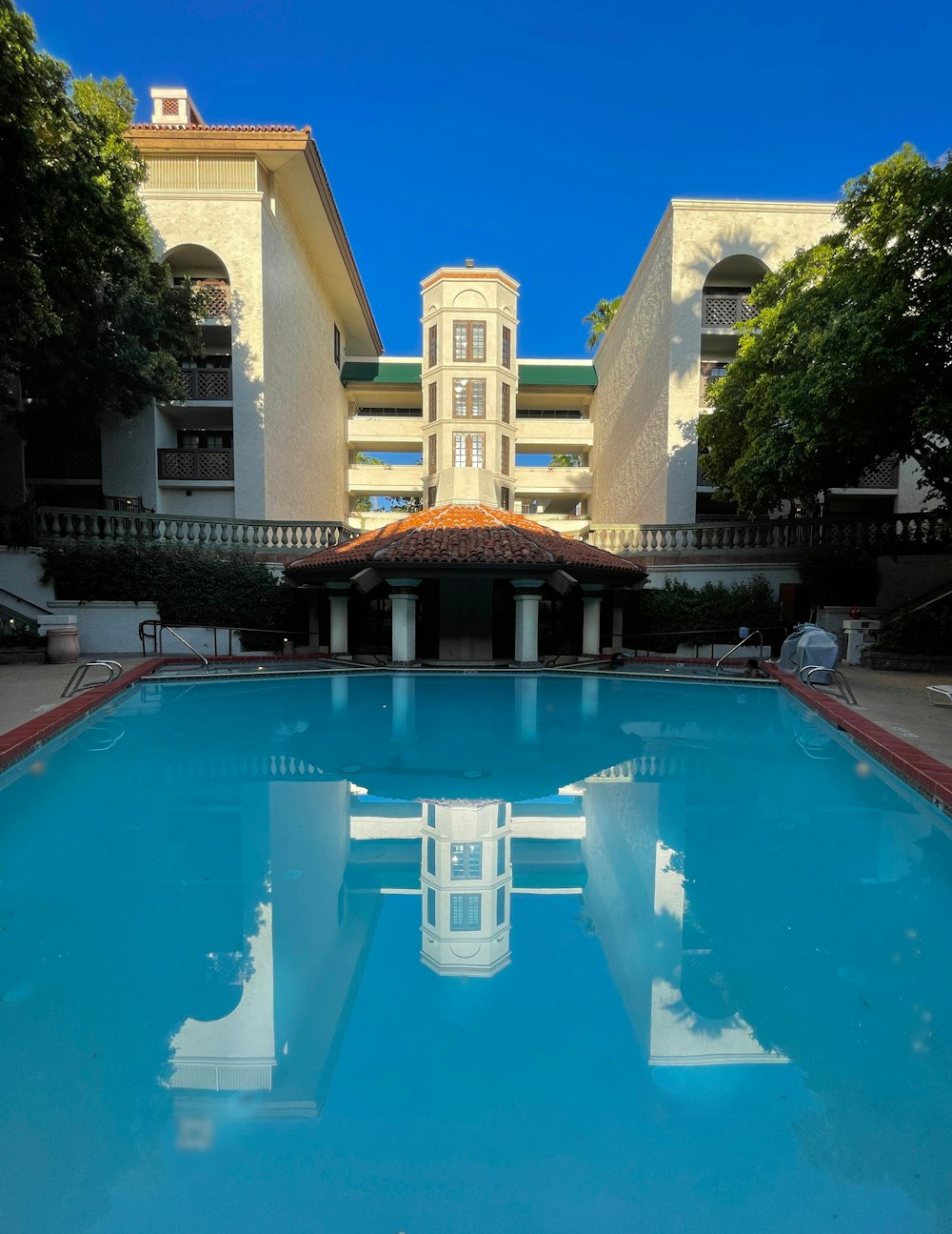 a large swimming pool with a building in the background