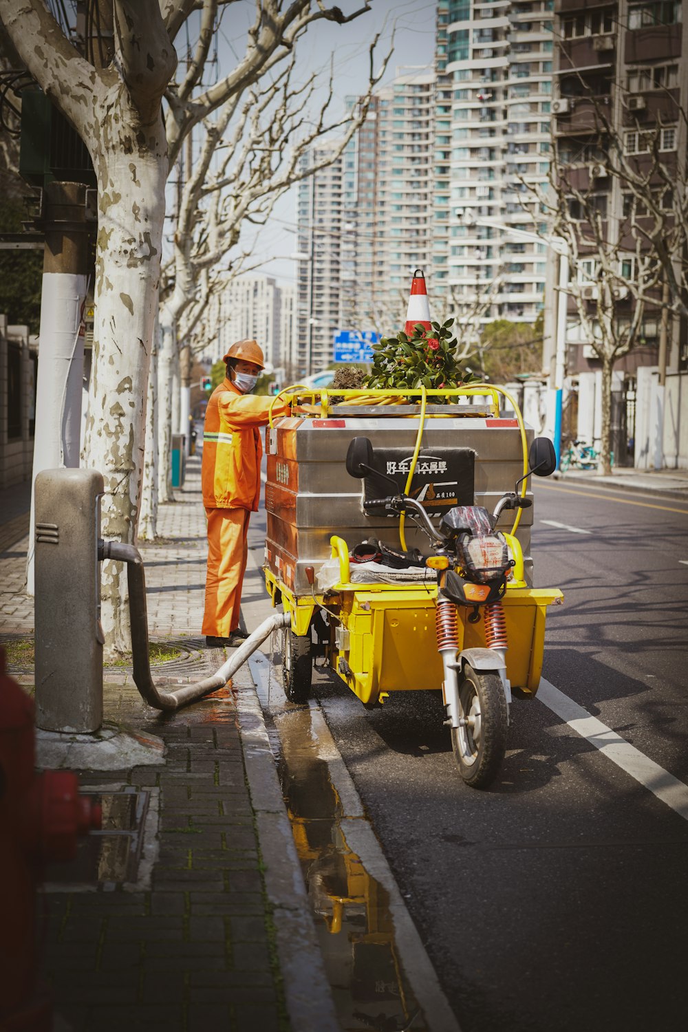 a man in an orange suit is cleaning a street