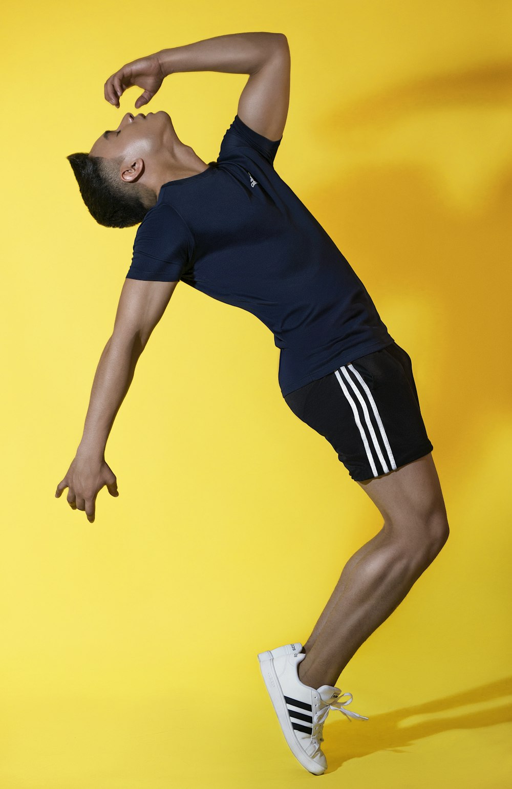 a man in a blue shirt and black shorts