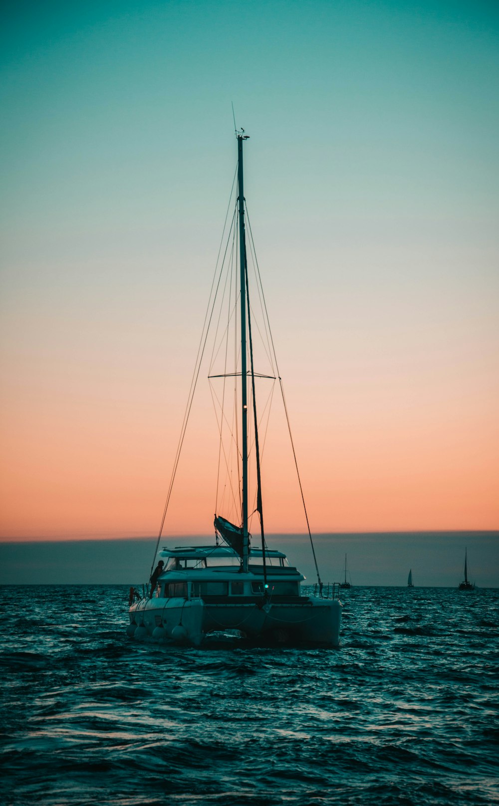 a sailboat in the ocean at sunset