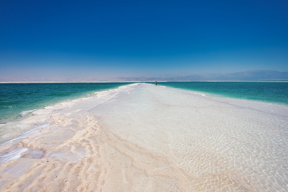 a long stretch of white sand stretches out into the ocean