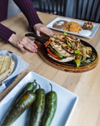 Fajitas served on a plate other plates of food
