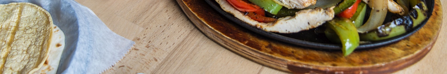 Fajitas served on a plate other plates of food