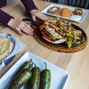 Fajitas served on a plate other plates of food