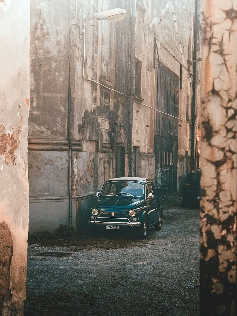 an old car is parked in an alley