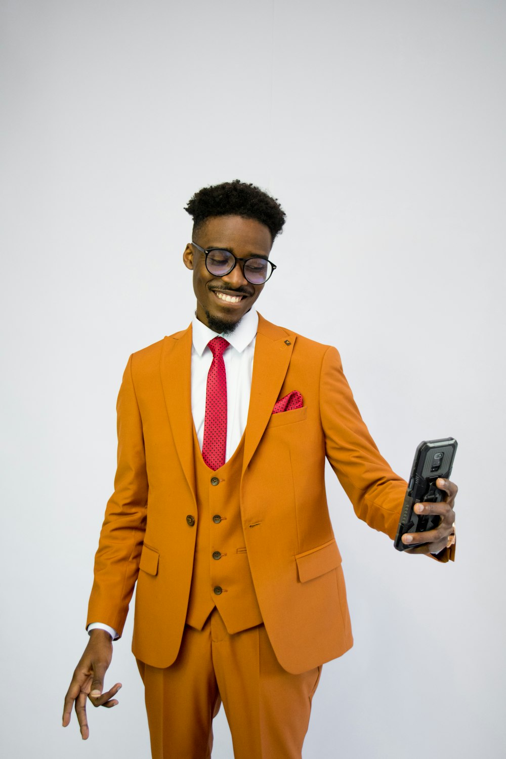 a man in an orange suit holding a cell phone