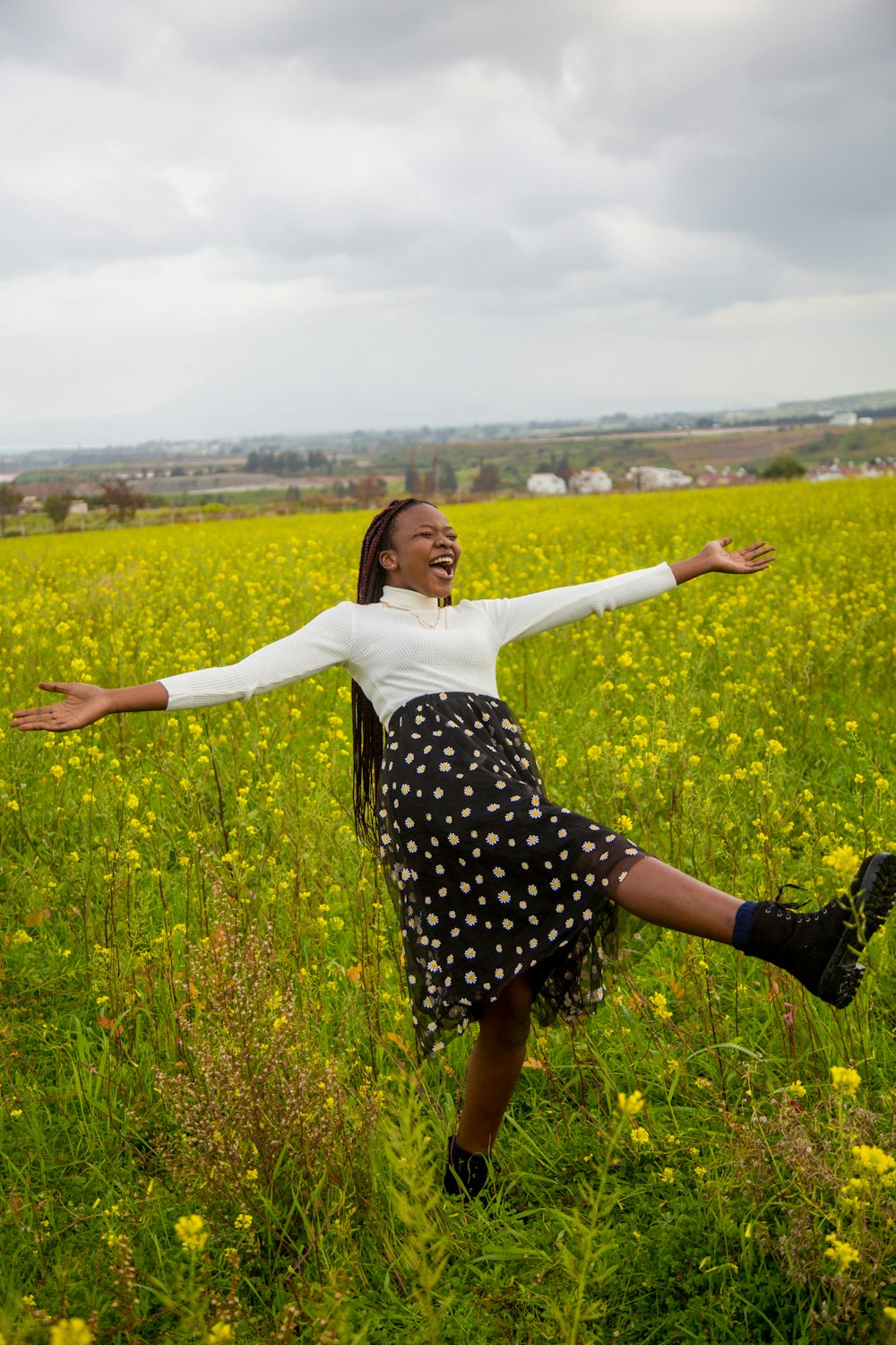 a woman standing in a field of yellow flowers