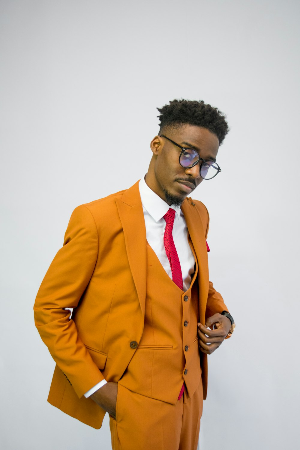 a man in an orange suit and red tie