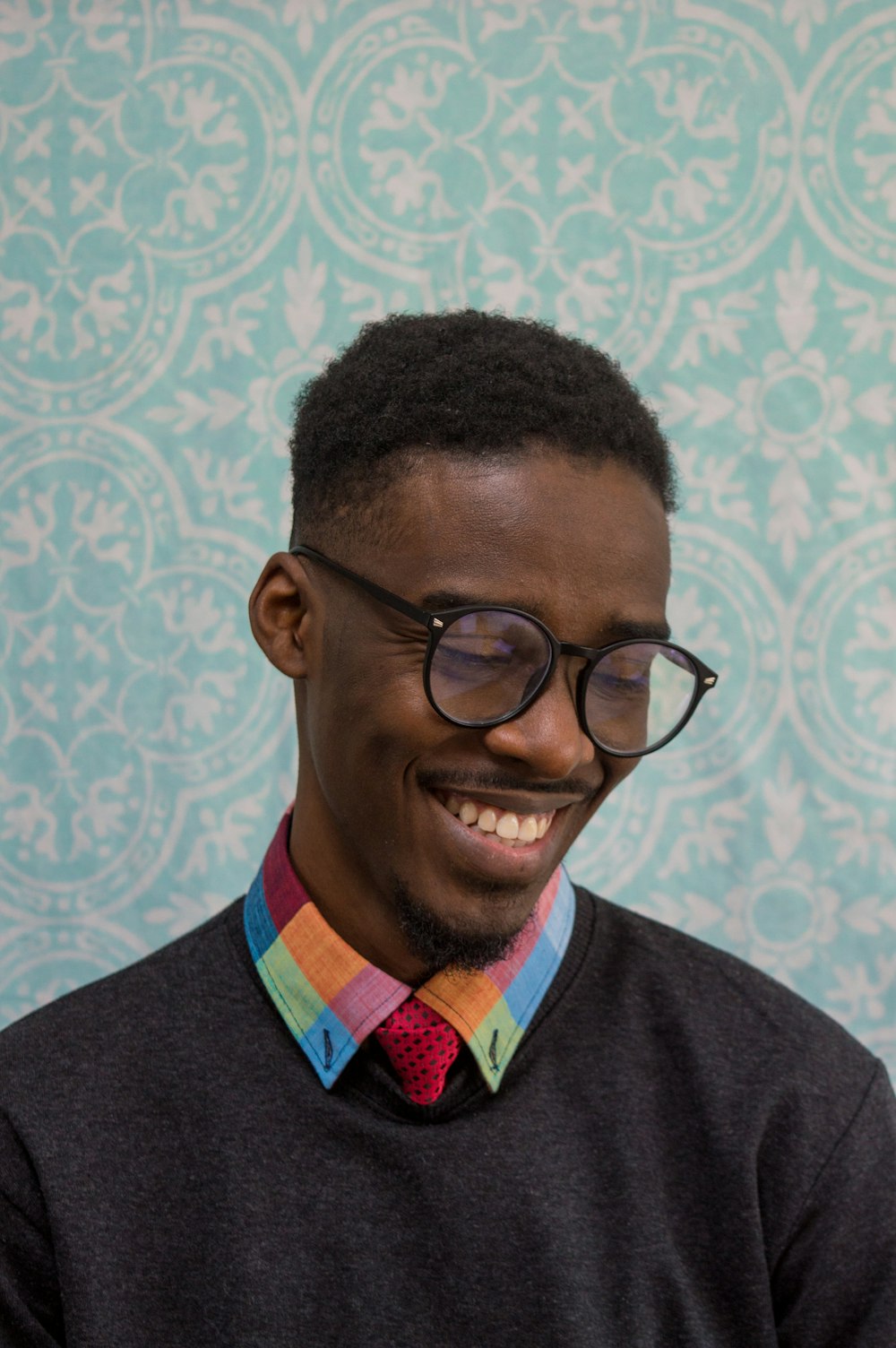 a man wearing glasses and a colorful tie