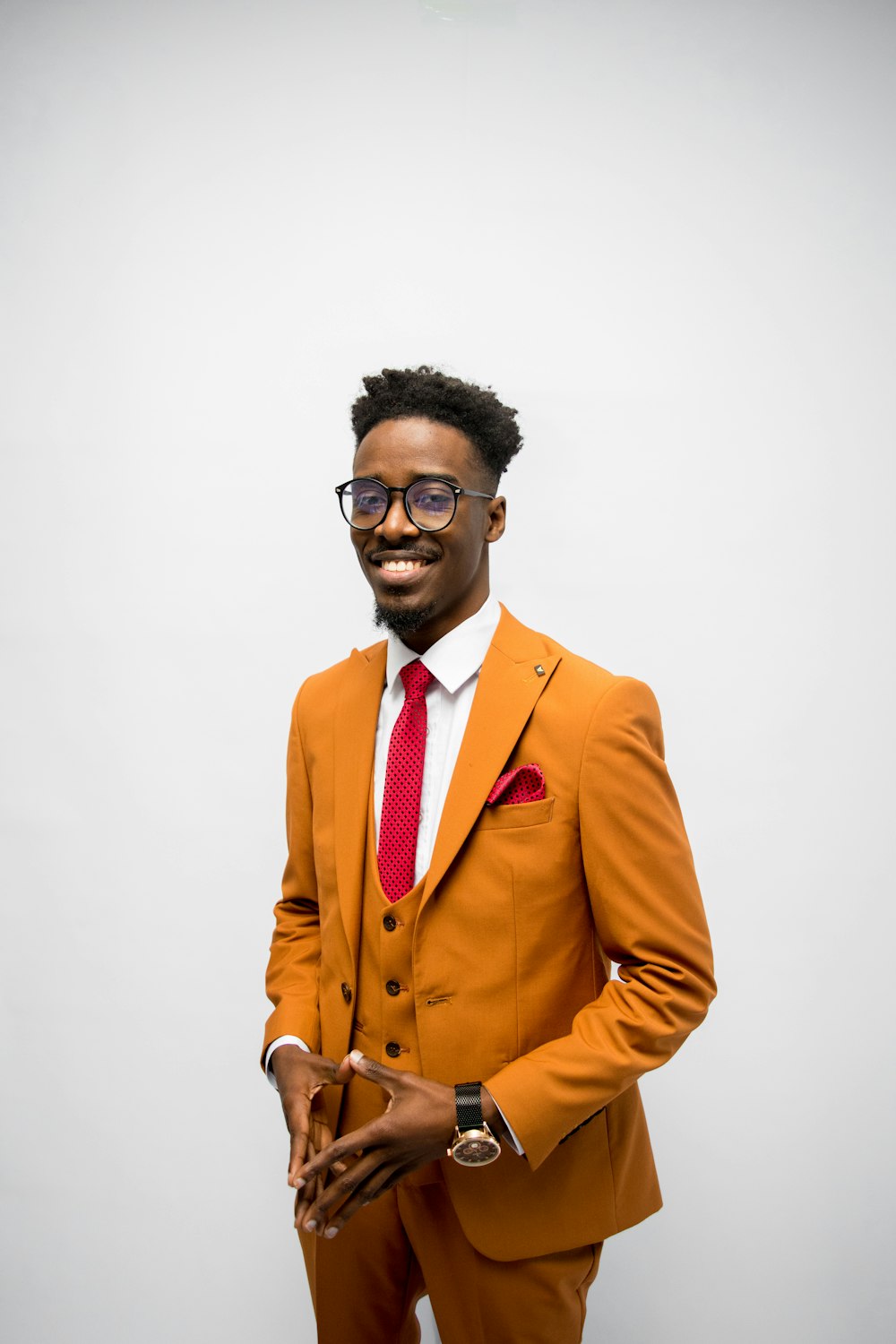 a man in an orange suit and red tie