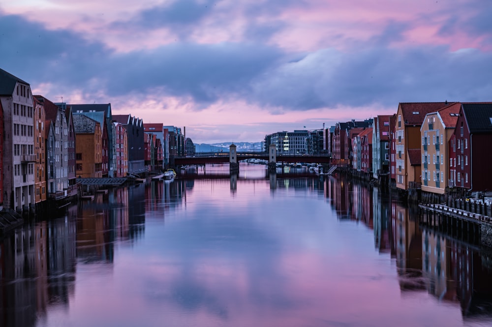 a river running through a city under a cloudy sky