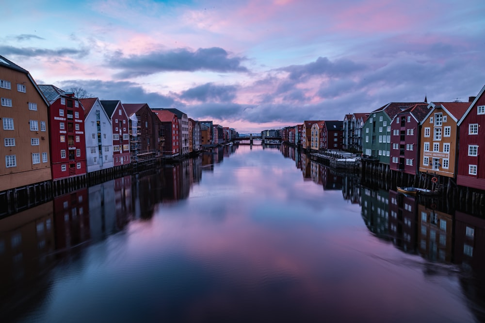 a body of water surrounded by buildings under a cloudy sky