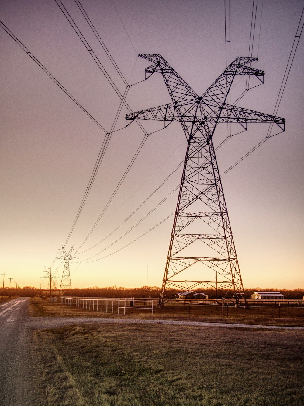 un grand poteau électrique assis sur le bord d’une route