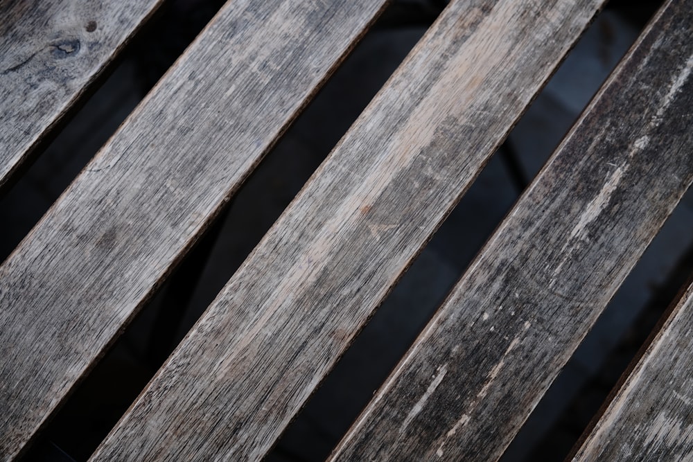 a close up of a wooden bench with peeling paint