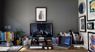 a desk with a computer and a laptop on it
