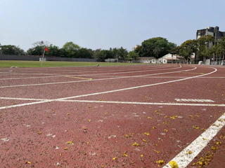 Athletes sprinting on a newly upgraded track facility with Railway maroon banners waving overhead