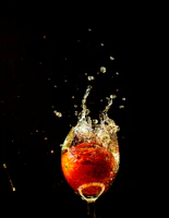 Dynamic splash of Long Jump energy drink pouring into a glass against a bright background.