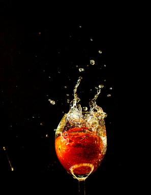 Dynamic splash of Long Jump energy drink pouring into a glass against a bright background.