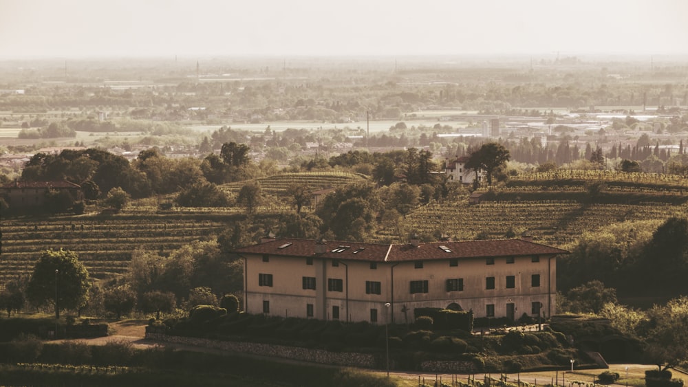 a large house sitting on top of a lush green hillside