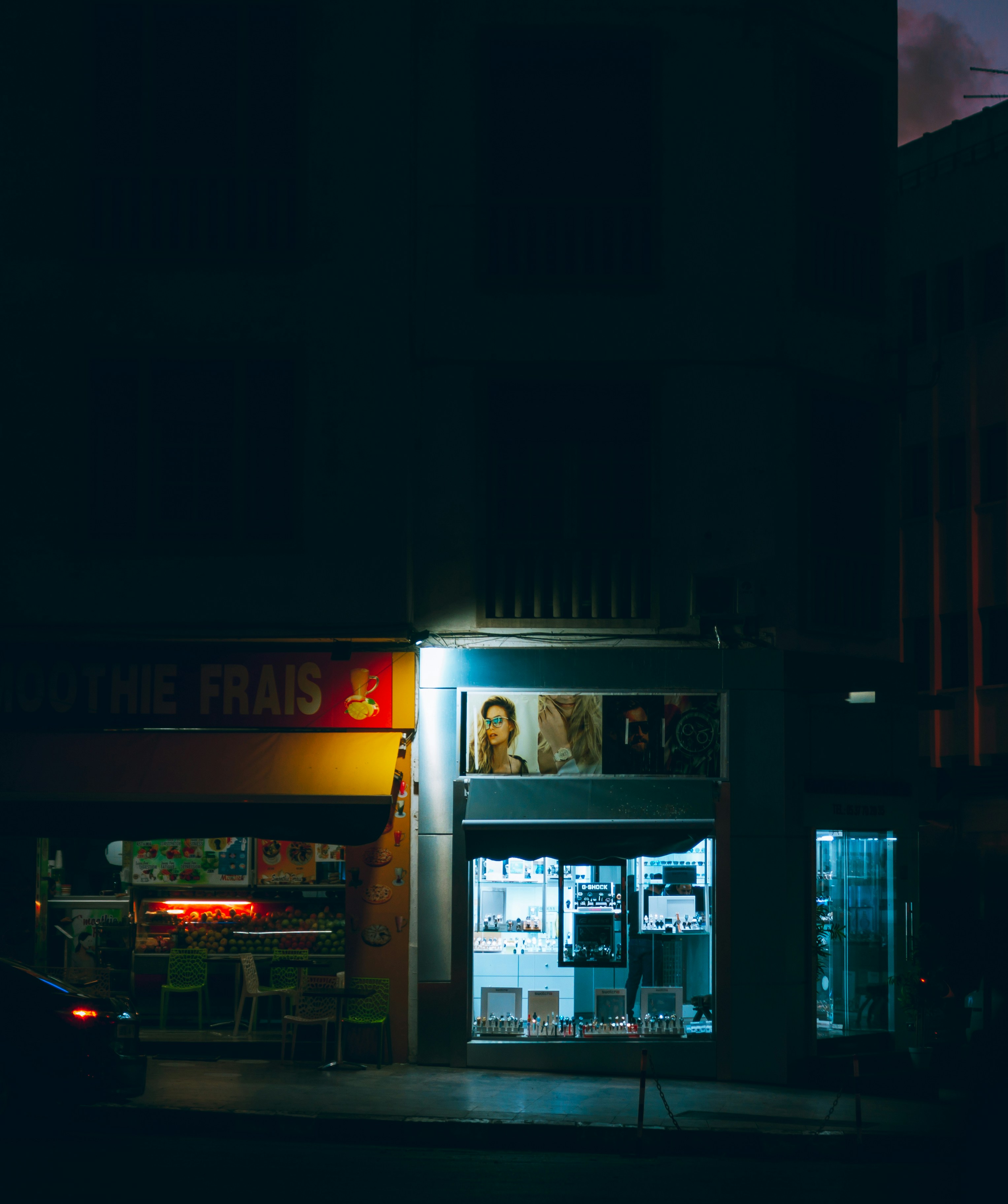 a dark street at night with a store front lit up