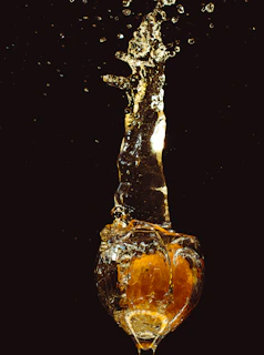 Artistic shot of vibrant juice drops falling into a wellness shot glass, highlighting freshness and bold flavors