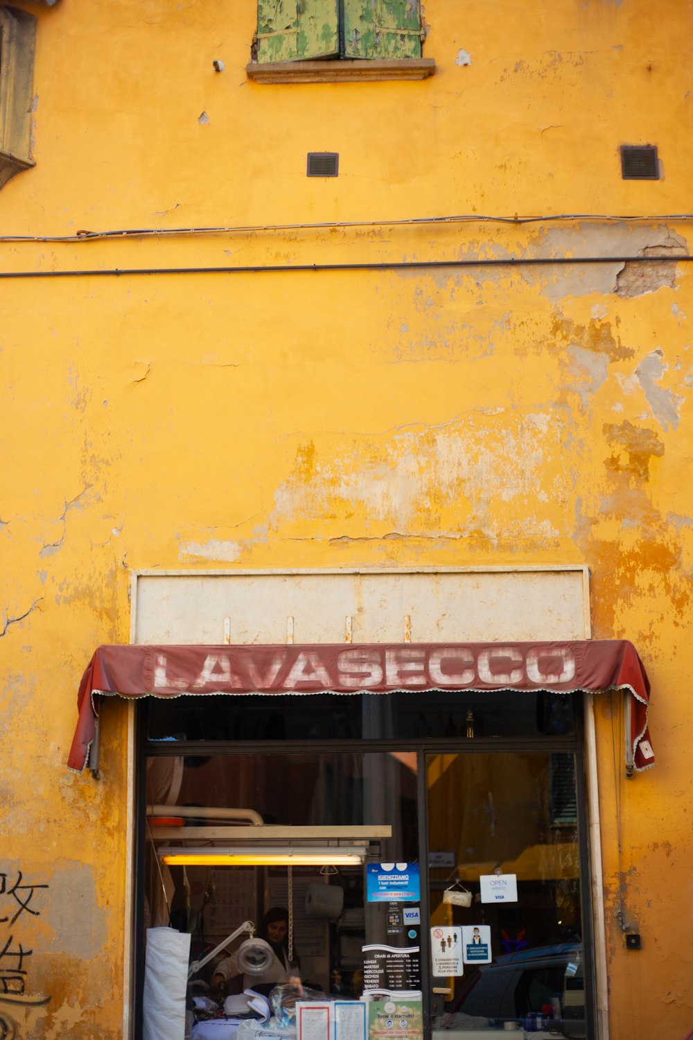 a yellow building with a red awning