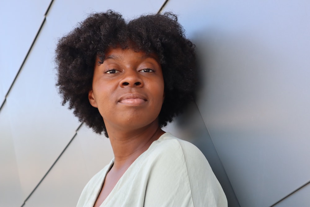 a young black woman leaning against a wall