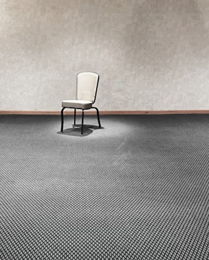 a chair sitting in a room next to a wall