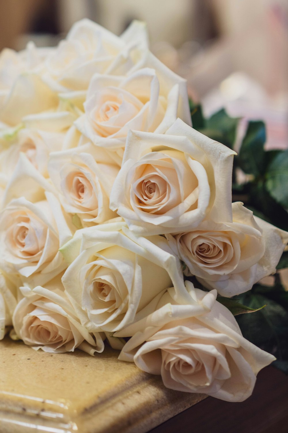 a bouquet of white roses sitting on top of a table