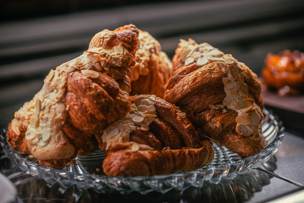 a glass bowl filled with croissants on top of a table