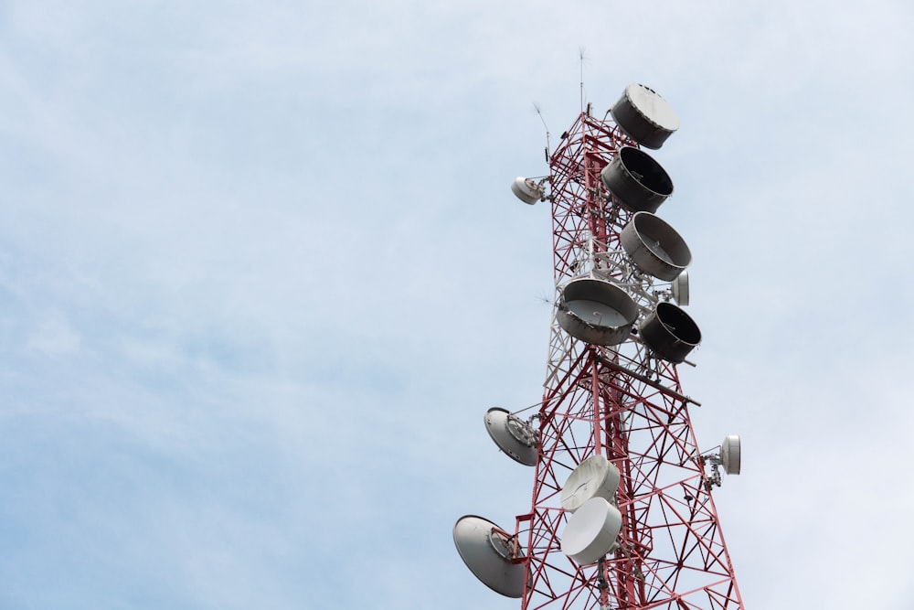 a very tall tower with lots of white dishes on top of it