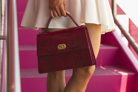 a woman in a white dress carrying a red purse