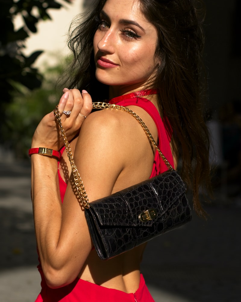 Woman in Red Dress Holding Black Croc Embossed Purse