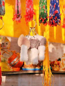 Close-up of traditional Mexican keychains with intricate embroidery and bright colors hanging on a display