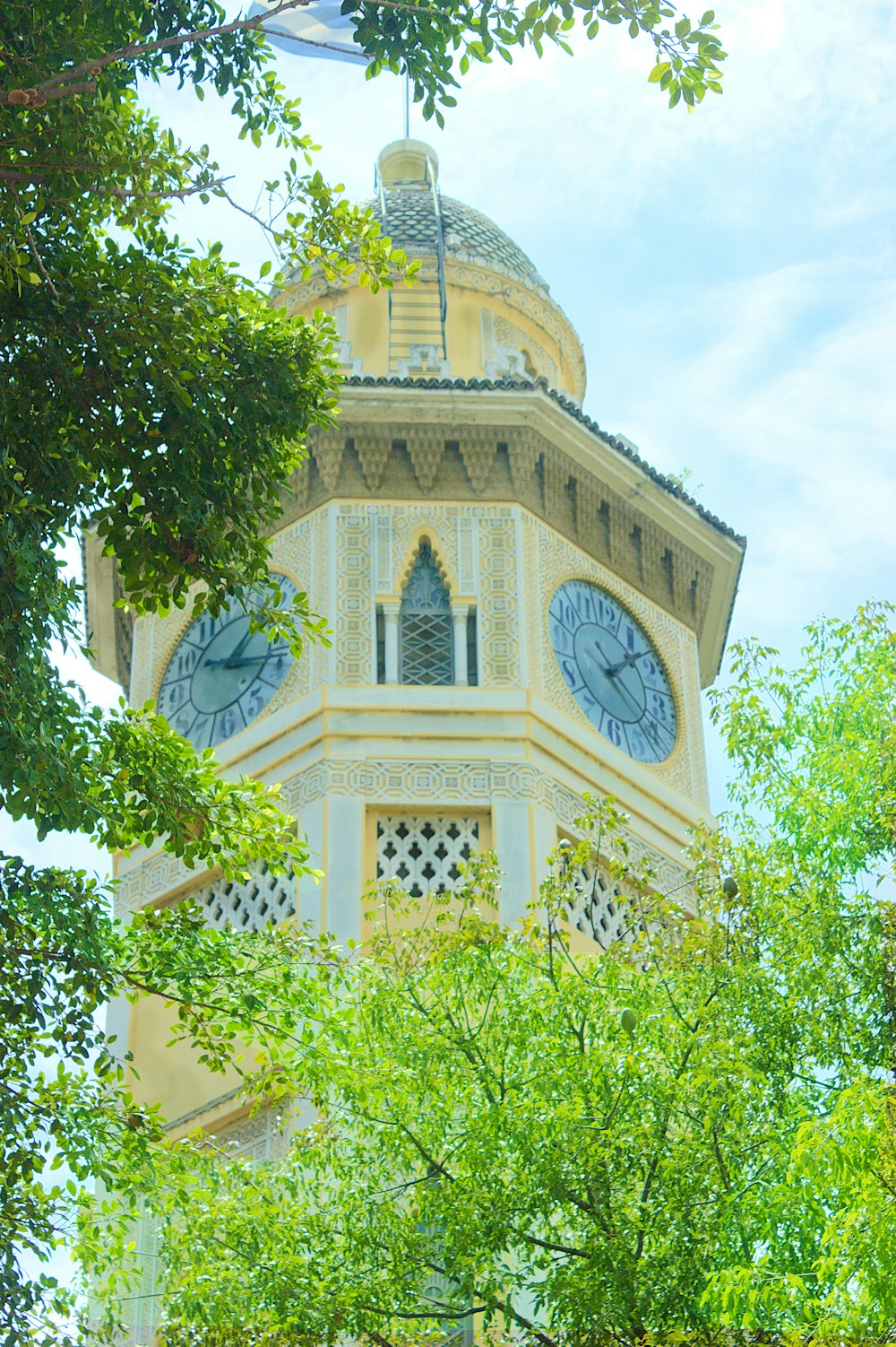 a tall clock tower with two clocks on each of it's sides