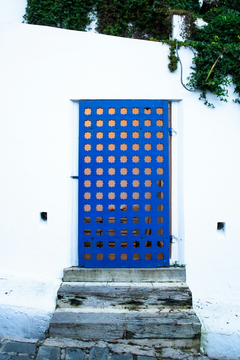 a blue door on the side of a white building