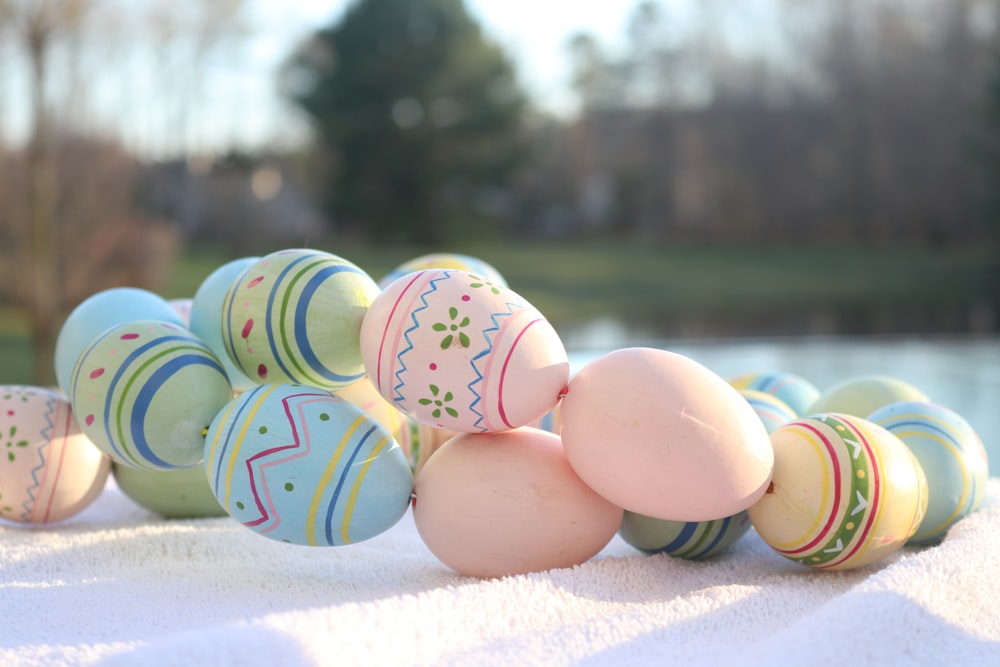 a row of painted eggs sitting on top of a snow covered ground