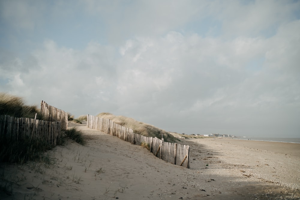 a beach with a fence and sand dunes