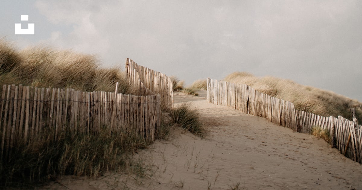 Foto zum Thema Ein Sandweg, der zu einem Sandstrand führt Kostenloses
