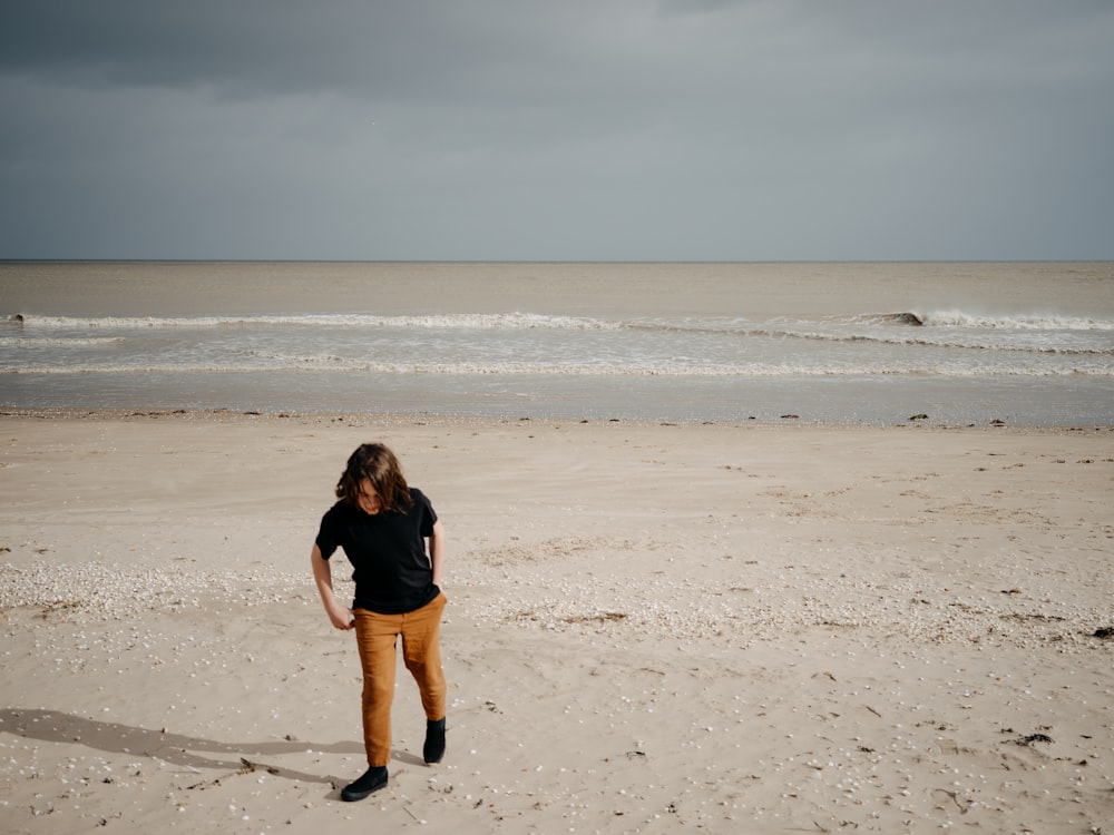 a woman standing on top of a sandy beach