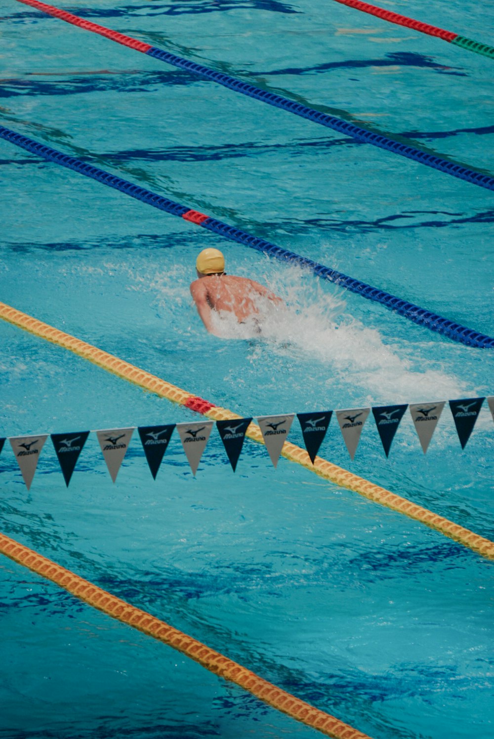 a man swimming in a pool surrounded by flags