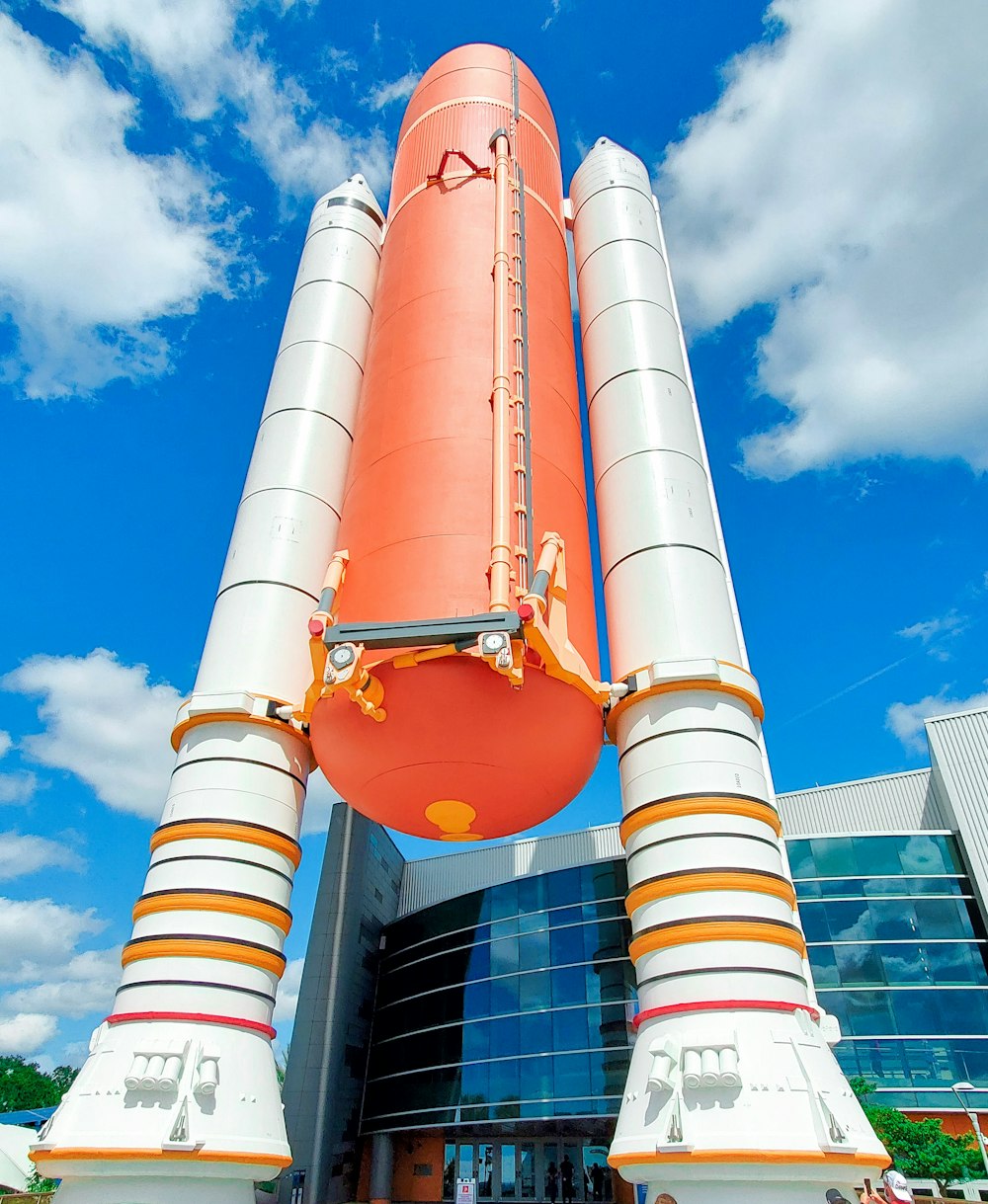 a large orange and white rocket sitting on top of a building