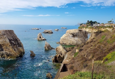 a scenic view of the ocean with rocks in the foreground